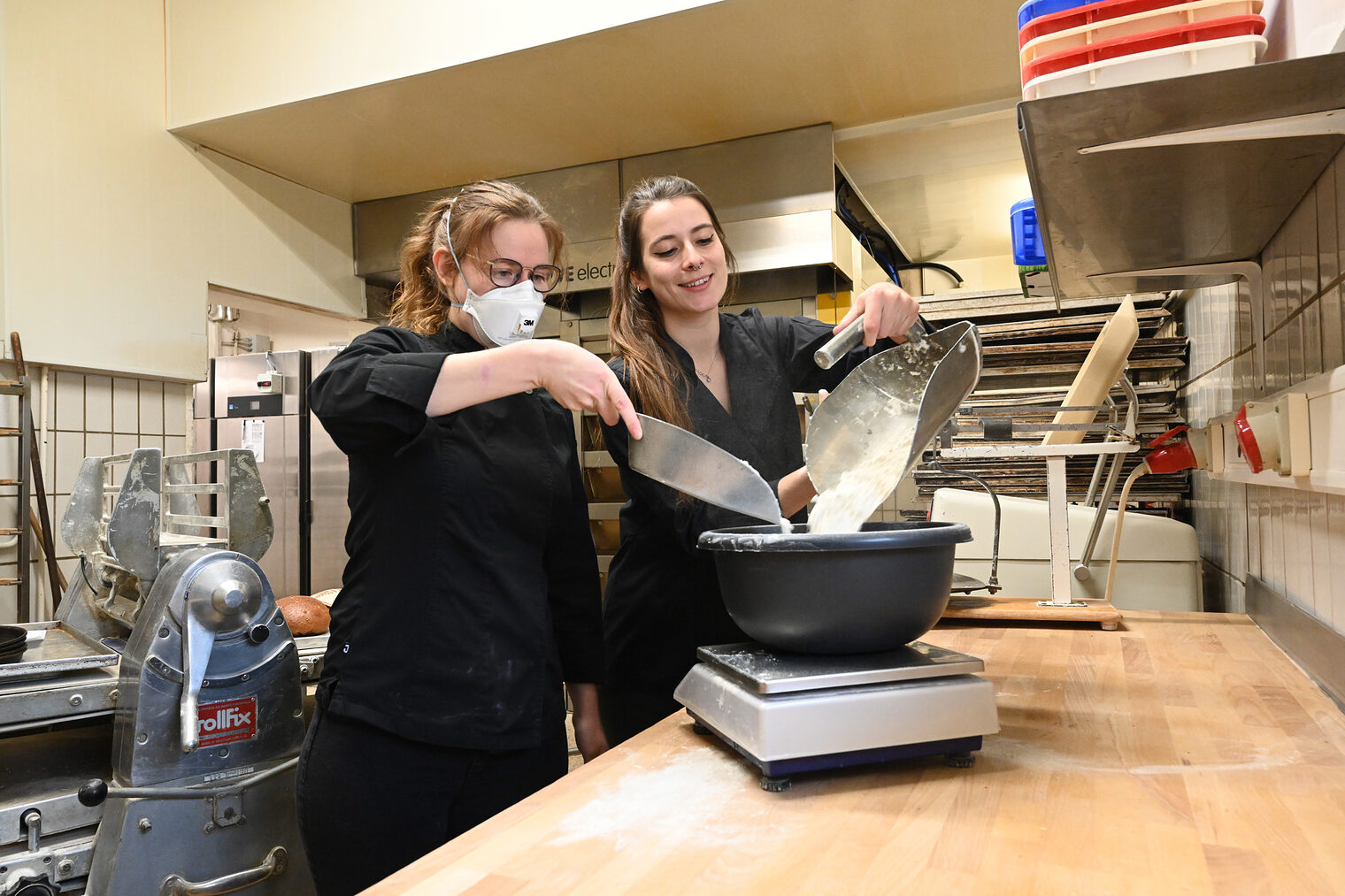 Deutsche Meisterinnen Bäckerhandwerk Bäckerinnen füllen gemeinsam Mehl in eine Schüssel auf einer Waage