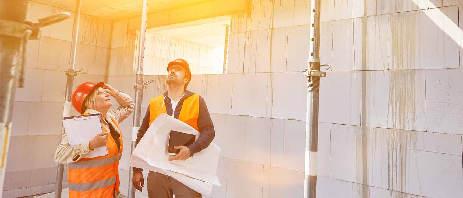 Sachverständigenwesen Handwerk Zwei Sachverständige auf einer Baustelle begutachten das Mauerwerk