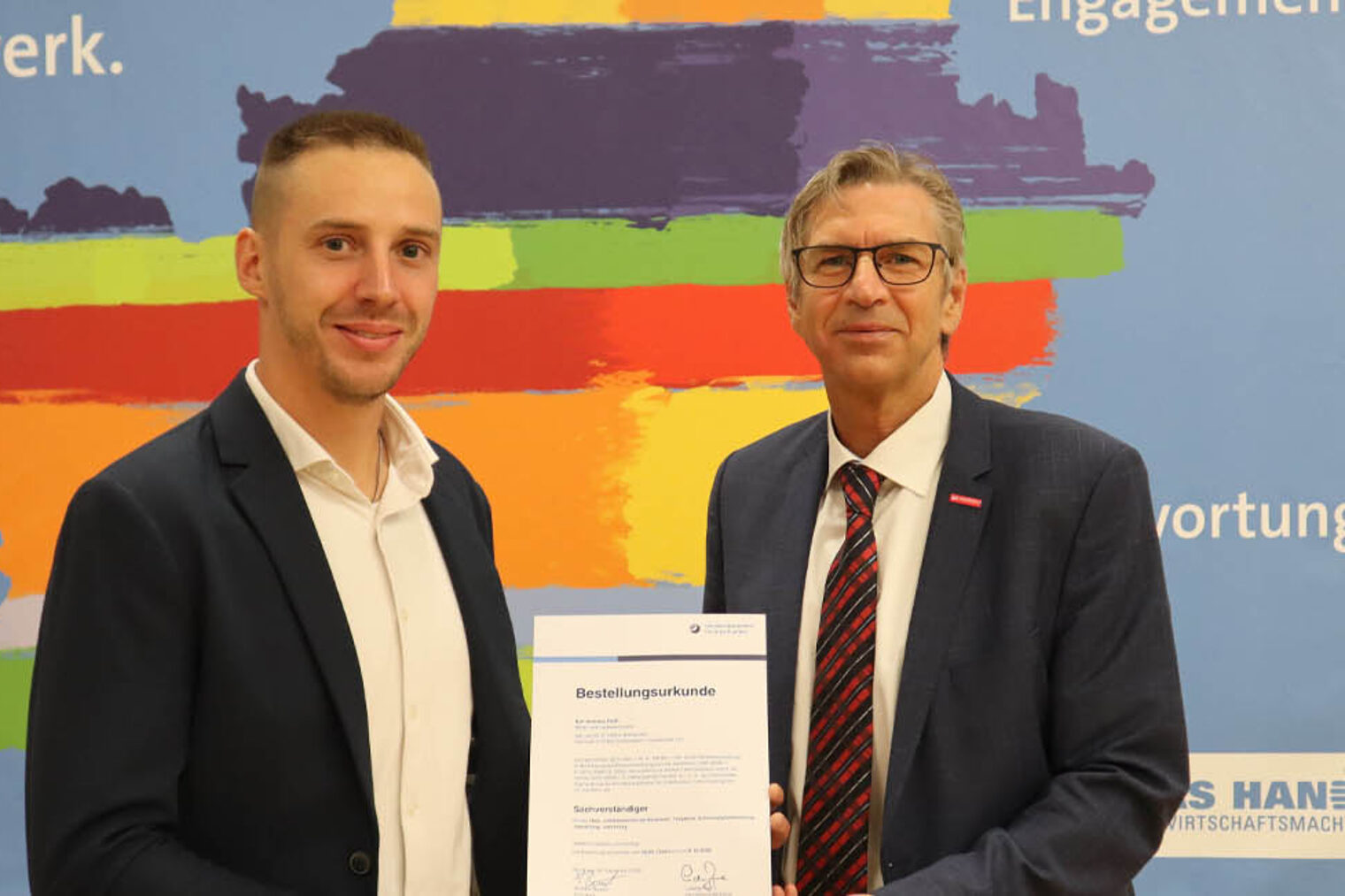 Vereidigung Sachverständige Andreas Förth Zwei Personen mit Urkunden blicken in Kamera