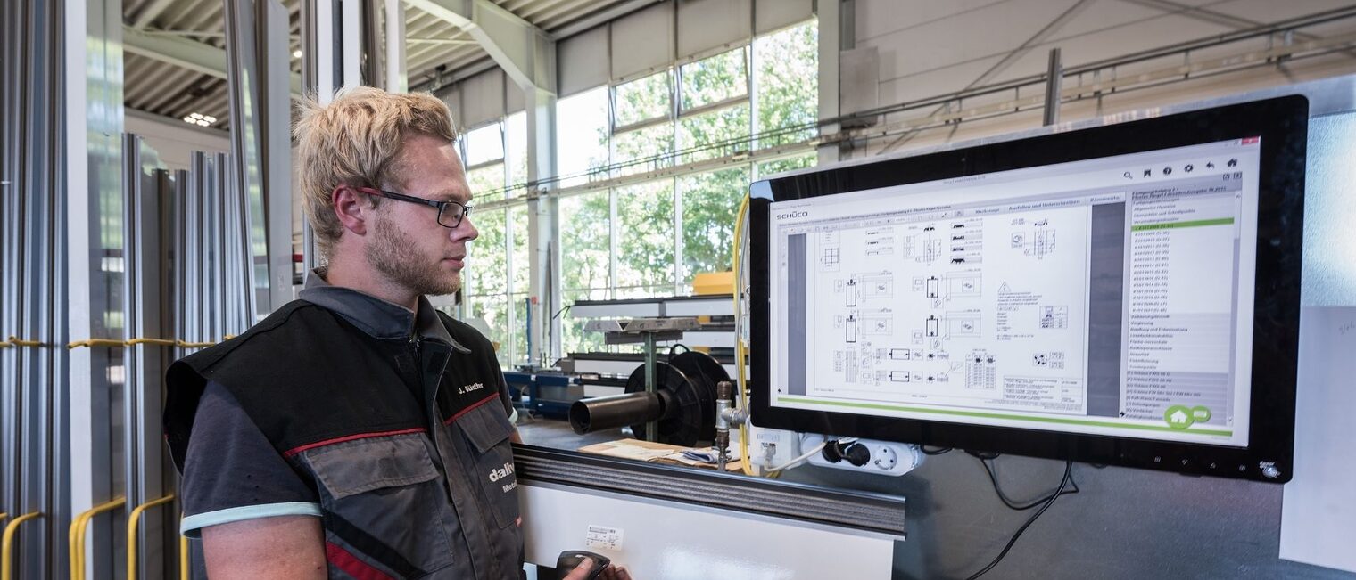 Technische Beratung Ein Mann steht vor einem großen Bildschirm und prüft ein Gerät