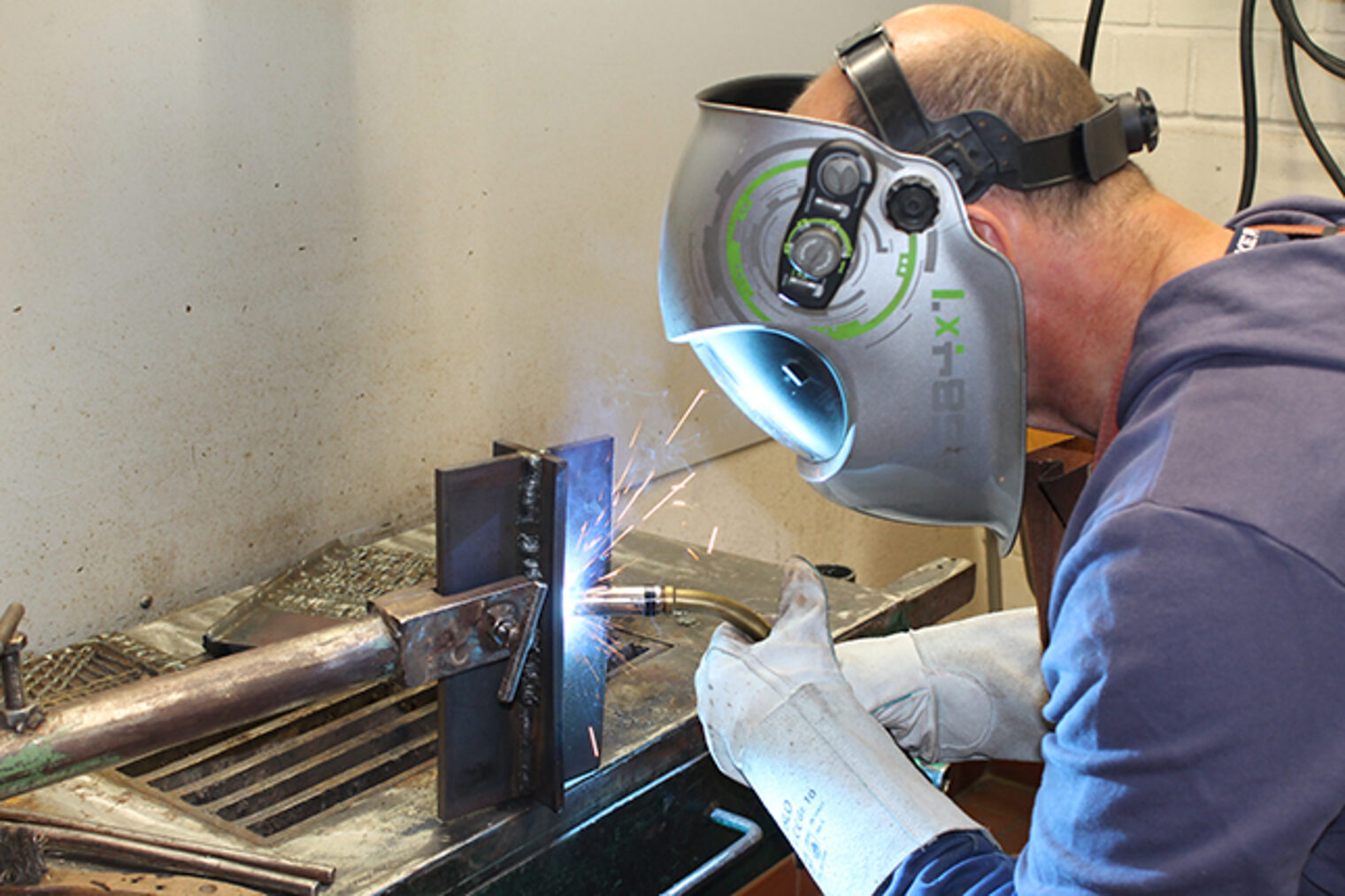 MAG-Schweißen Grundkurs: Teilnehmer bei Übung in Werkstatt Teilnehmer beim MAG-Schweißen-Grundkurs in der Handwerkskammer Aschaffenburg: Fokus auf Schweißübung und Sicherheit.