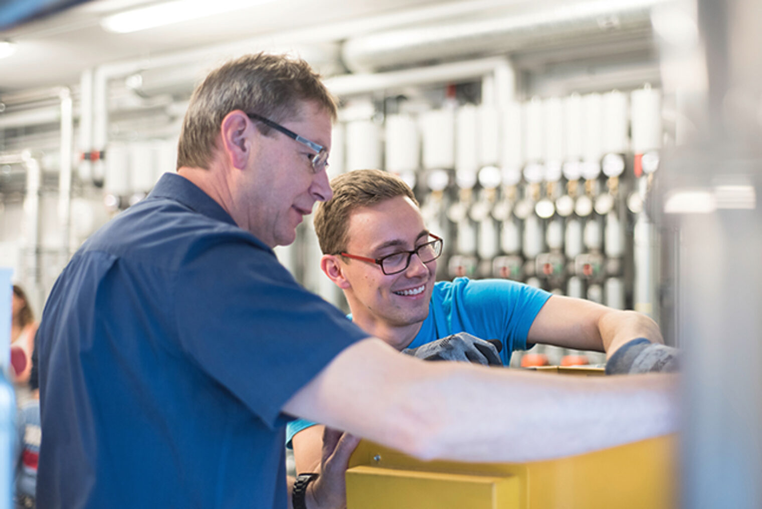 Weiterbildung SHK-Kundendiensttechniker/in in Aschaffenburg: Teilnehmer übt Wartung eines Wärmetauschers mit Dozent 