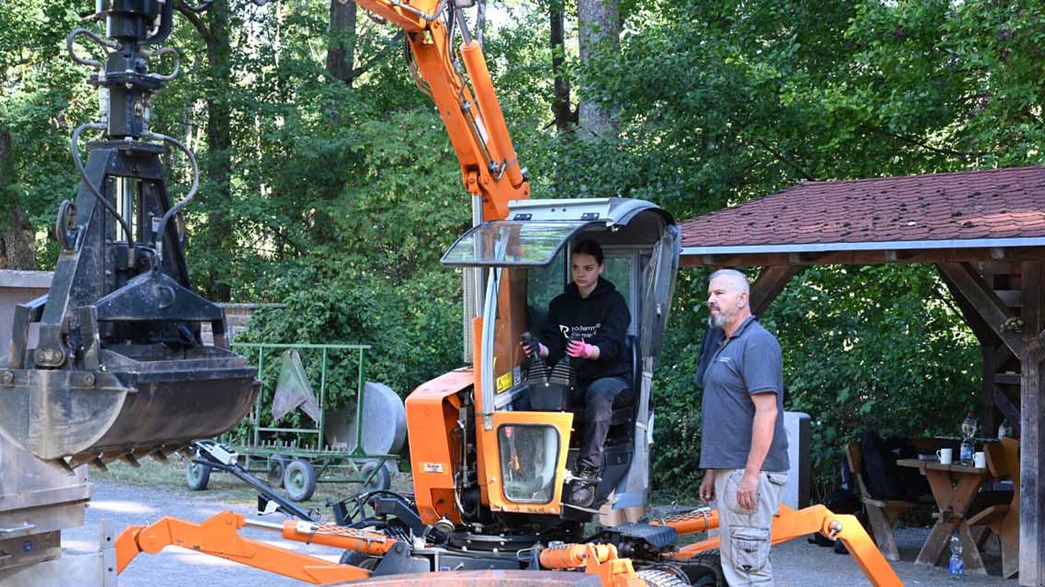Auszubildende auf Bagger, Dozent leitet an