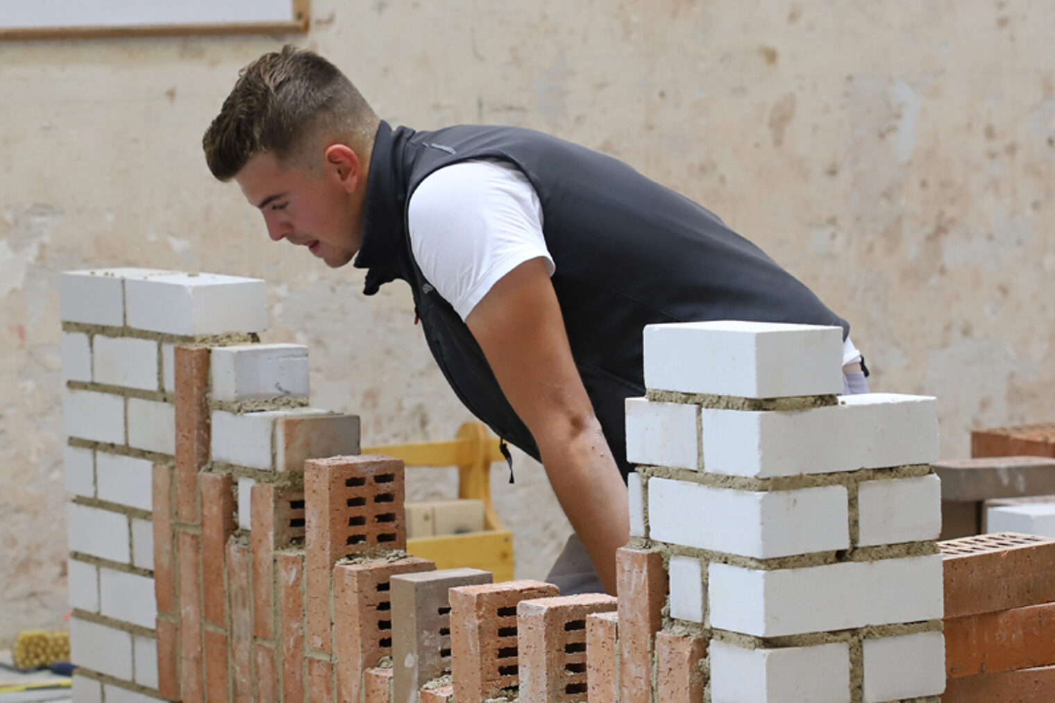 Maurer arbeitet an einer Mauer