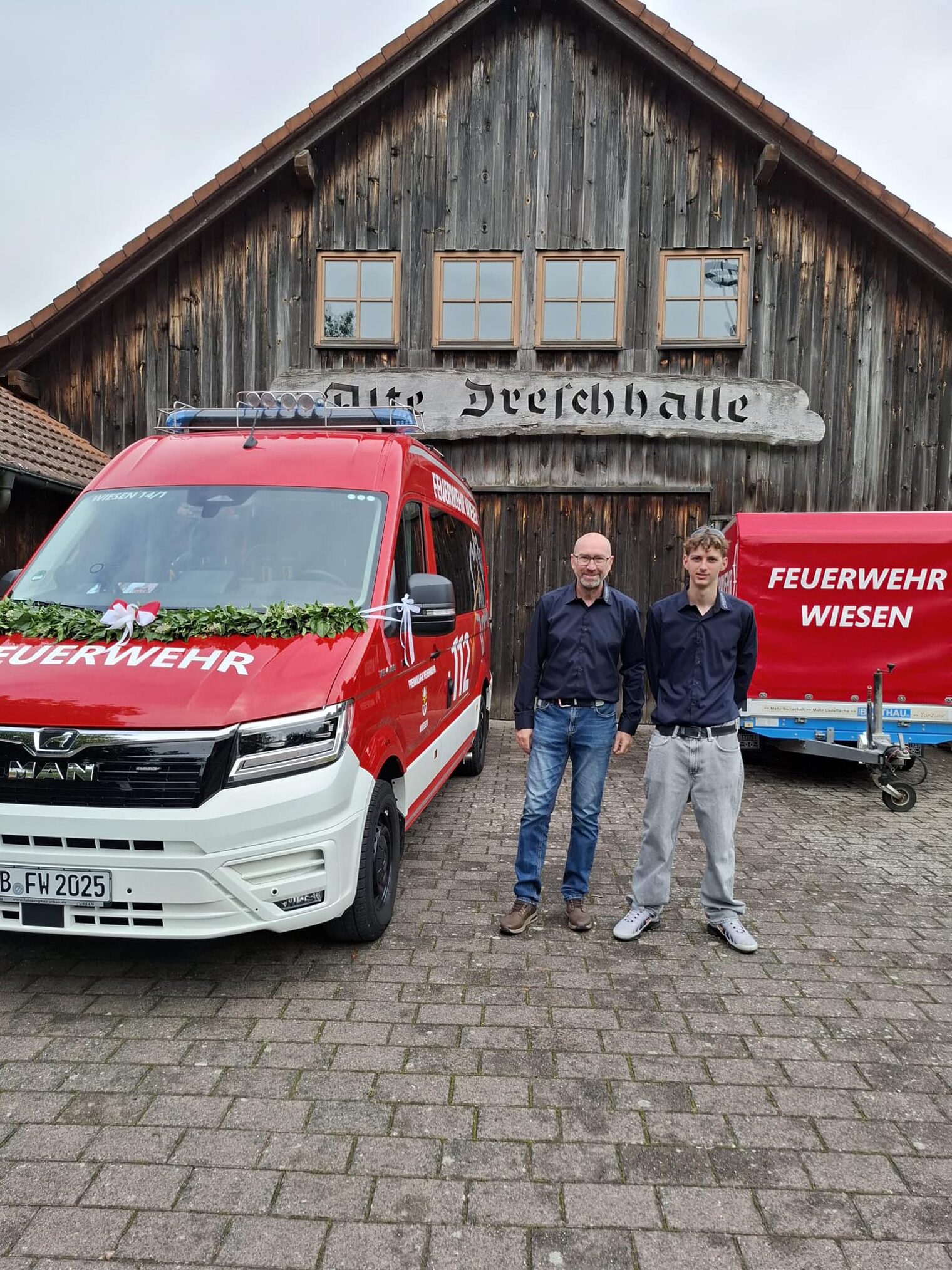 Zwei Personen bei Übergabe von Feuerwehrautos