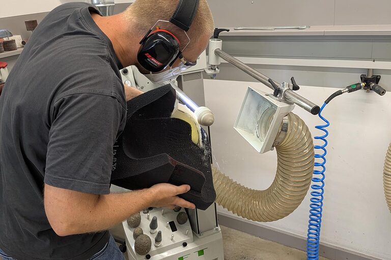 Orthopädiemechaniker an Schleifmaschine